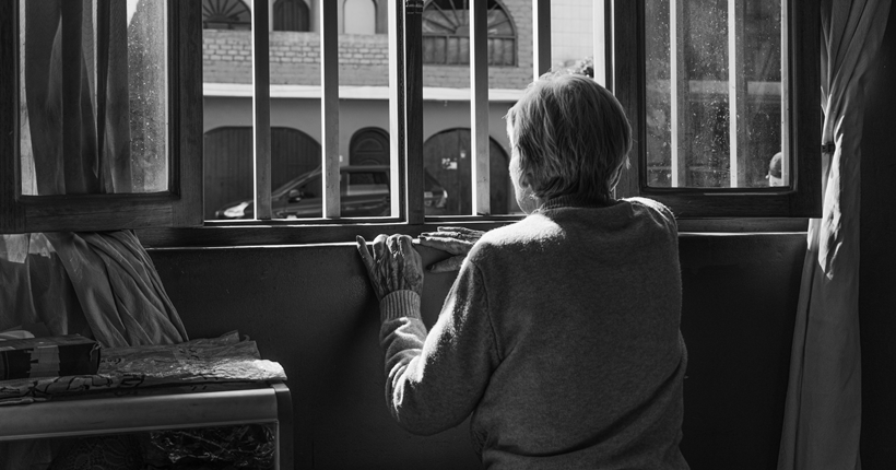Una mujer mira por una ventana. Imagen ilustrativa del artículo sobre voluntades anticipadas del CRE Alzheimer. Fuente: Imserso.